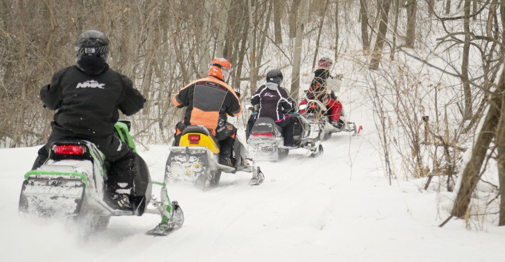 Four snowmobiles riding down Luce Line Trail in Hutchinson