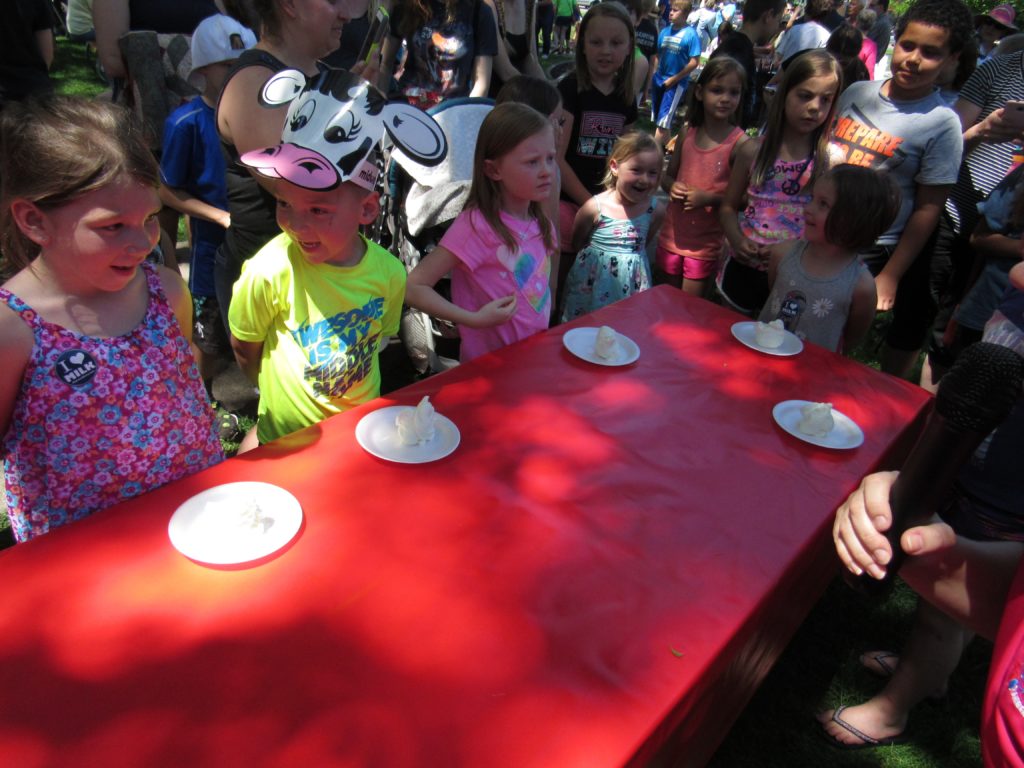 Children standing by table in frozen yogurt eating contest