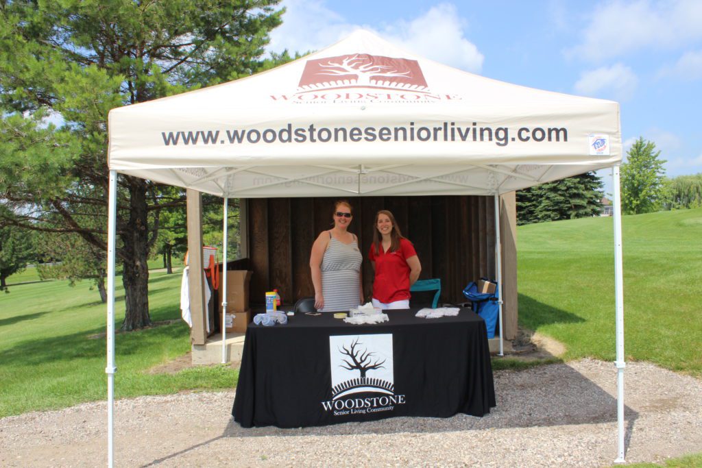 Two Woodstone Senior Living staff members pose at their booth