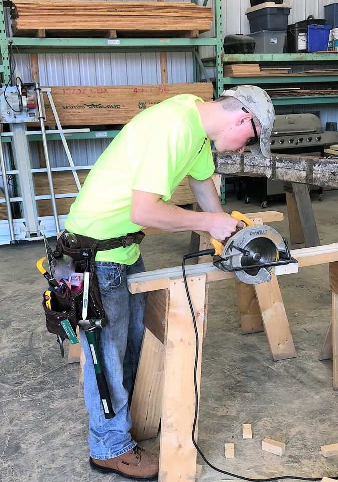 Construction worker using a circular saw to cut wood